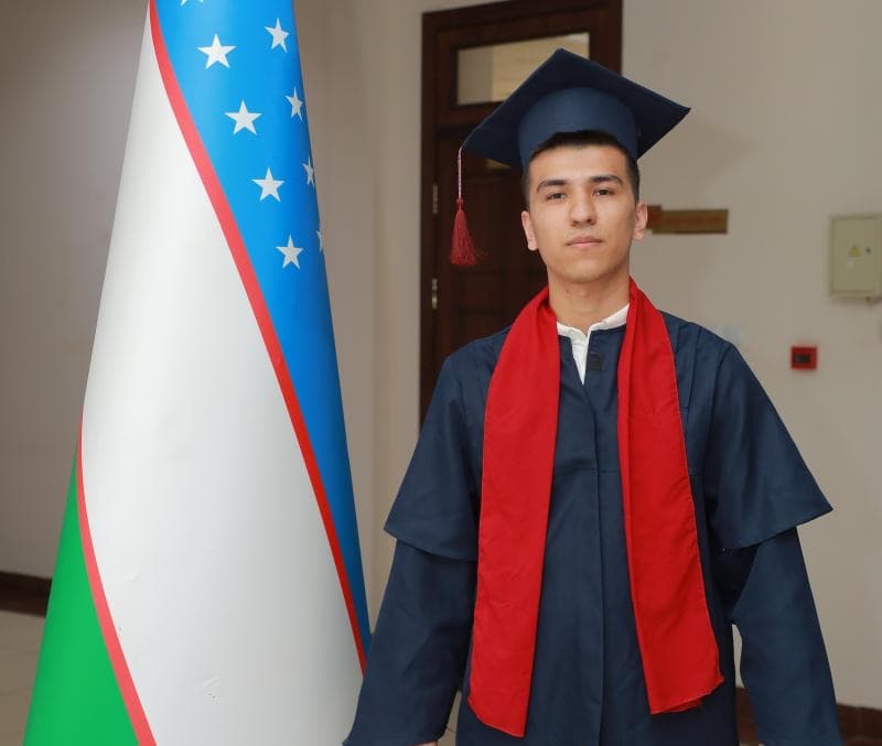 Kamron Fozilov in TUIT graduation gown.